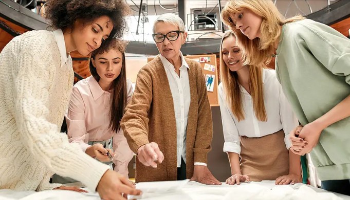 A group of women of all ages collaborating at a work table