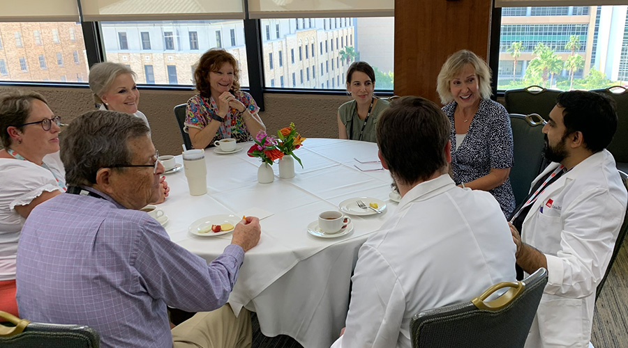 Kimberly Skarupski sitting at a table with a group of faculty