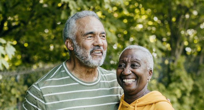 A senior man and woman standing together and smiling