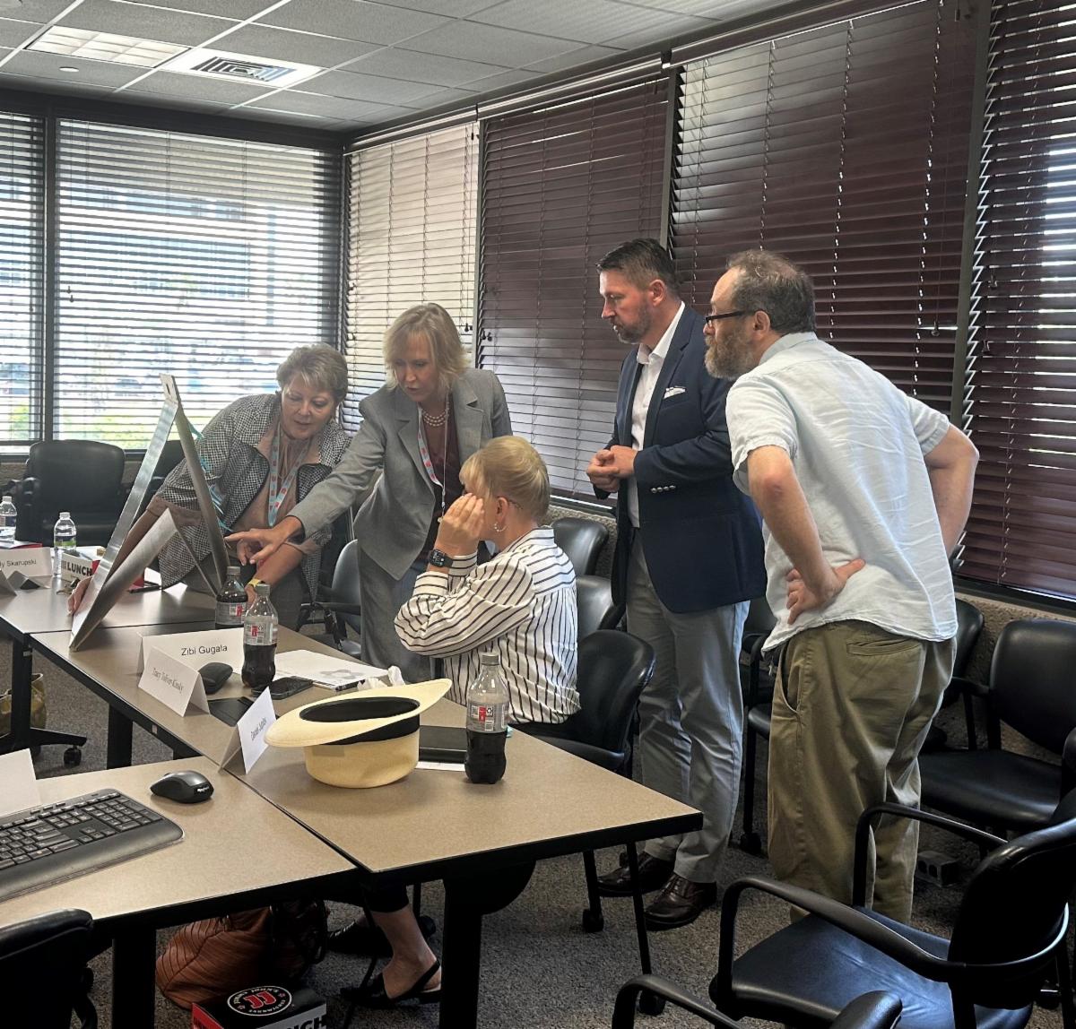 group of people looking at a flip chart and discussing the contents