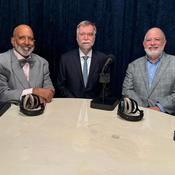 three men sitting in a podcast studio