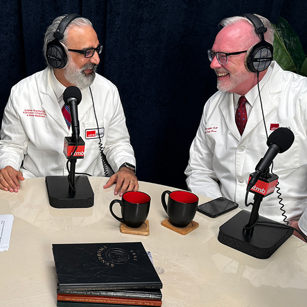 Dr. Gulshan Sharma and Dr. Jerry Mansfield wearing headphones looking at each other