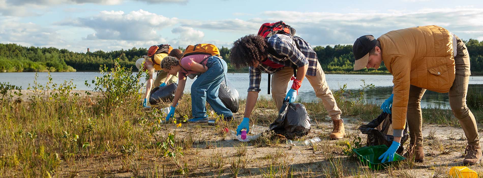 A diligent team works together to clean a lake's shore, contributing to environmental conservation